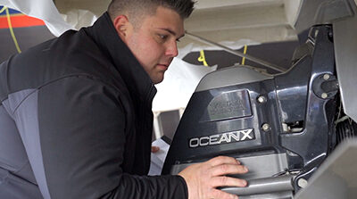 Maple Leaf Marina Marine Technician inspecting boat engine 