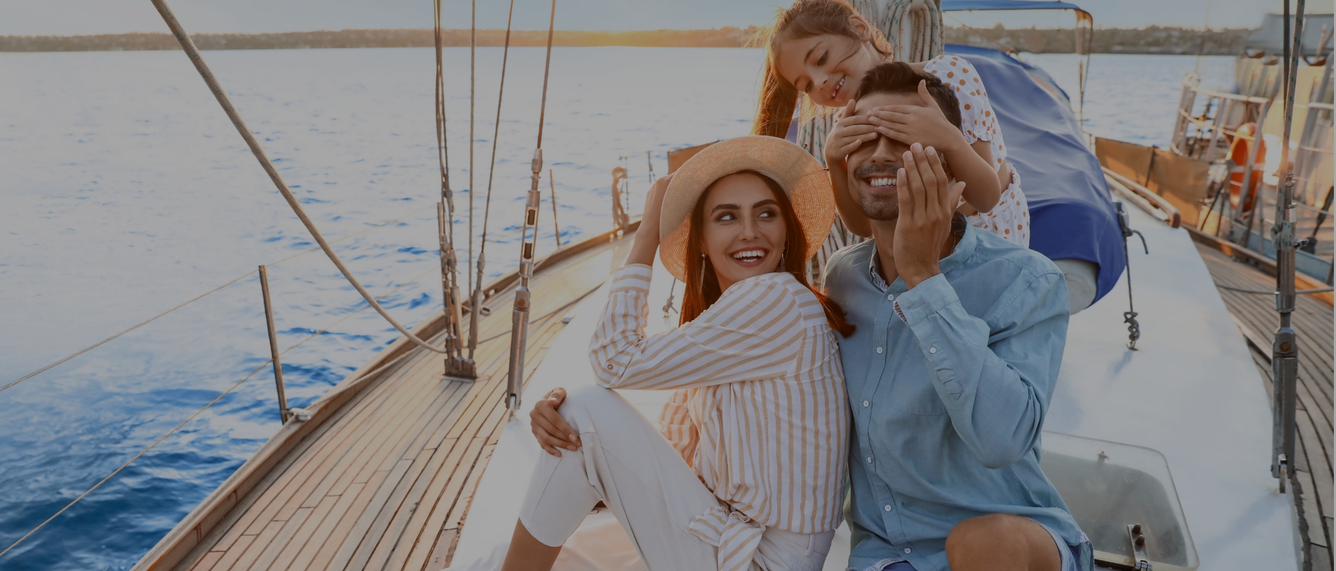 Young family on a sailboat enjoying a beautiful sunset during the remainder of summer after switching to a Maple Leaf Marina during the August Deal promotion